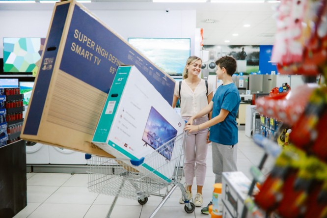 Mom and son buying large TV sets in the shopping mall, taking them out to the parking lot.